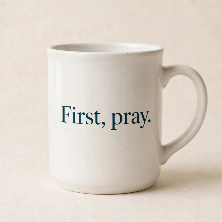 "First, pray." Mug — mug only, warm off-white background